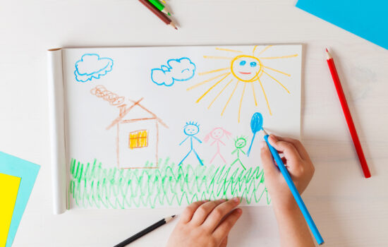 Child draws a pencil drawing of the house and his family. New home. Top view.